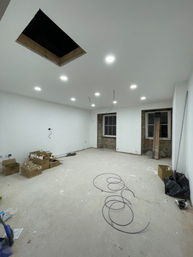 Interior of a partially completed room with exposed ceiling and construction materials.